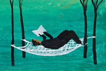 A woman reads a book while resting on a hammock between trees