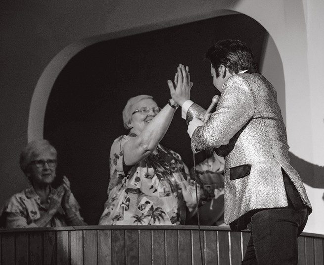 Dwight Icenhower reaching out to touch his hand against a woman's during a performance