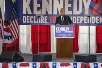 Robert F. Kennedy Jr. speaking at a lectern in front of a banner that says "Declare your independence"