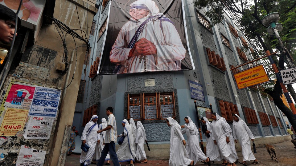 Nuns walk past a large banner of Mother Teresa ahead of her canonization ceremony in Kolkata, India, on September 4, 2016.
