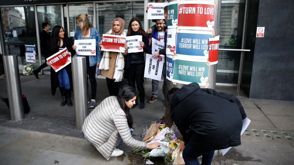 People lay flowers outside the New Zealand House following the Christchurch mosque attacks.