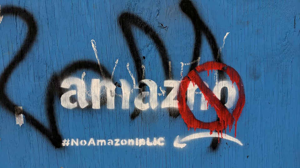 Graffiti opposing the construction of the new Amazon campus covers a fence in Long Island City, Queens.