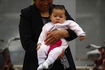 A woman holds a baby.