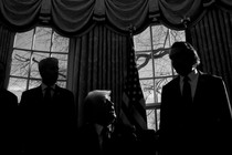 A dark photo of Trump with other advisers