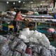 a woman works in a warehouse with clothes piled up