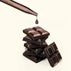 An image of chocolate squares with a lab dropper above them.