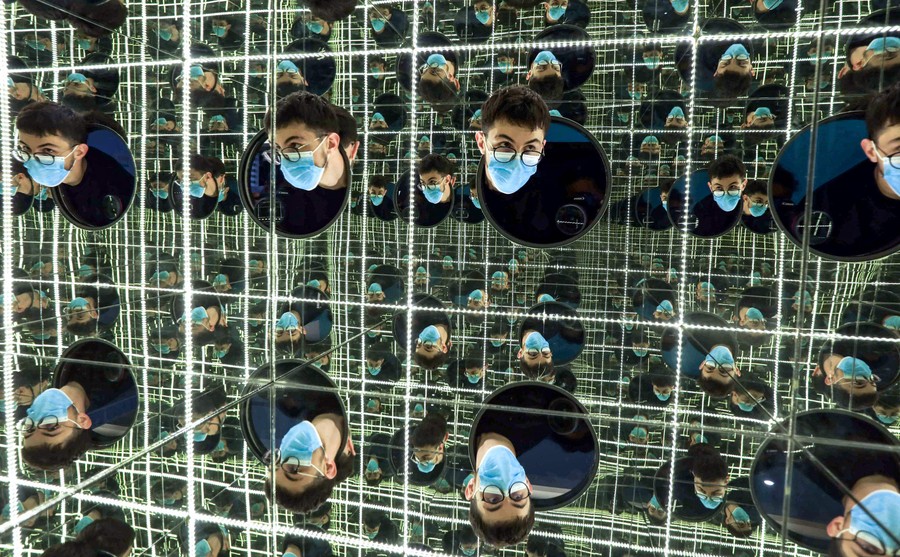 A person's head can be seen reflected dozens of times in a mirrored box.