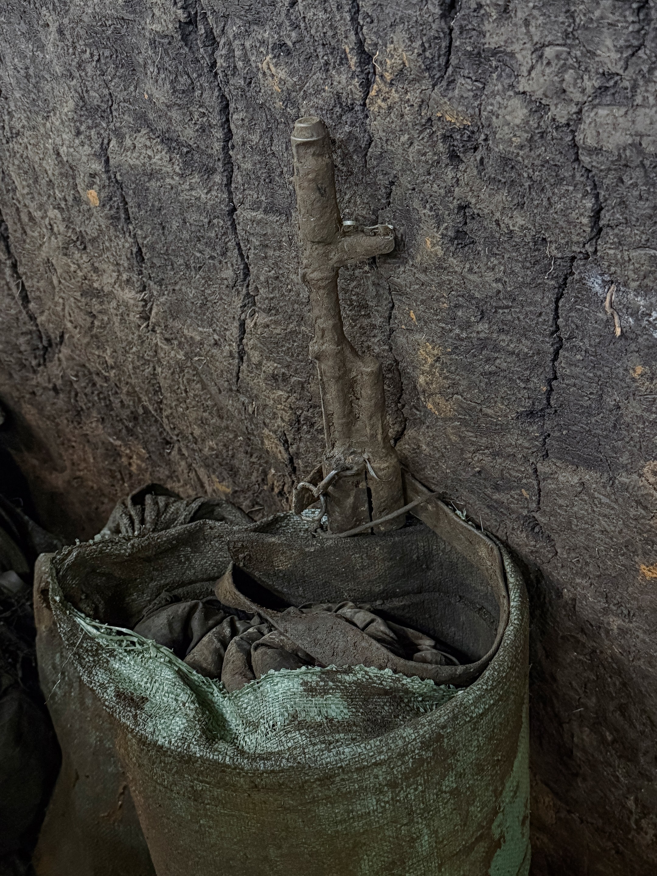 a rifle and bag covered in mud