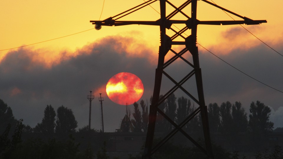 Power lines against a smoky red sky