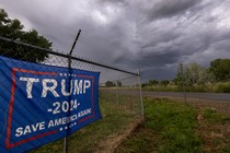 A storm brews in the sky above a Trump 2024 flag