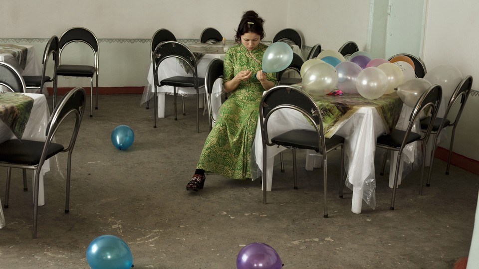 a woman sits at a table with balloons