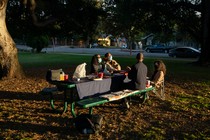 A family eating holiday dinner outside.