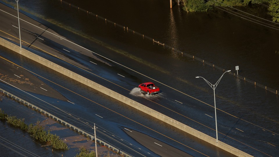 A car drives through flood waters along Interstate 95 after Hurricane Matthew hit Lumberton, North Carolina. 