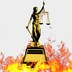 A statue of lady justice is surrounded by flames.
