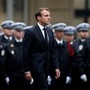 Emmanuel Macron walks past a line of police officers in formation during a ceremony to honor the four victims of the Paris police-headquarters killings.