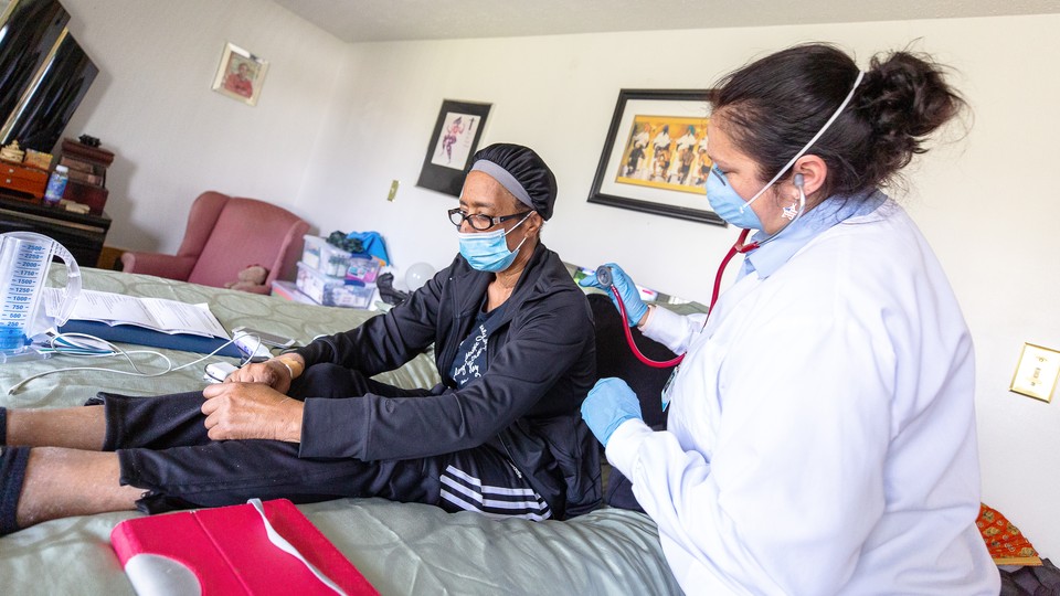 An in-home nurse cares for a woman while she recovers from COVID-19 at her home in Baltimore, Maryland.