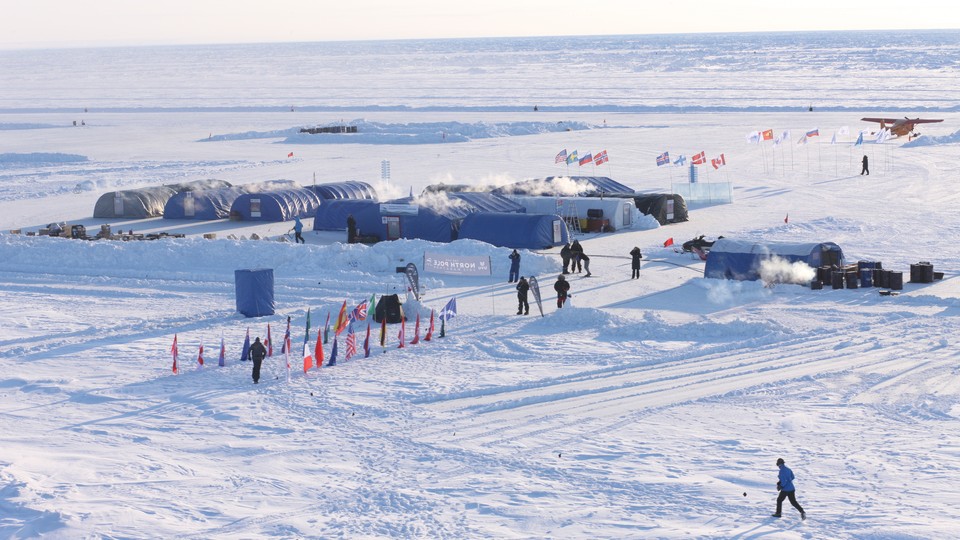 A photo of an ice camp with multiple tents and flags from many nations