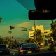 photo from interior of car of streetlight on Rodeo Drive, with palm trees and blue sky