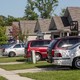 A photo from 2016 of various kind of cars in people's driveways on a suburban street