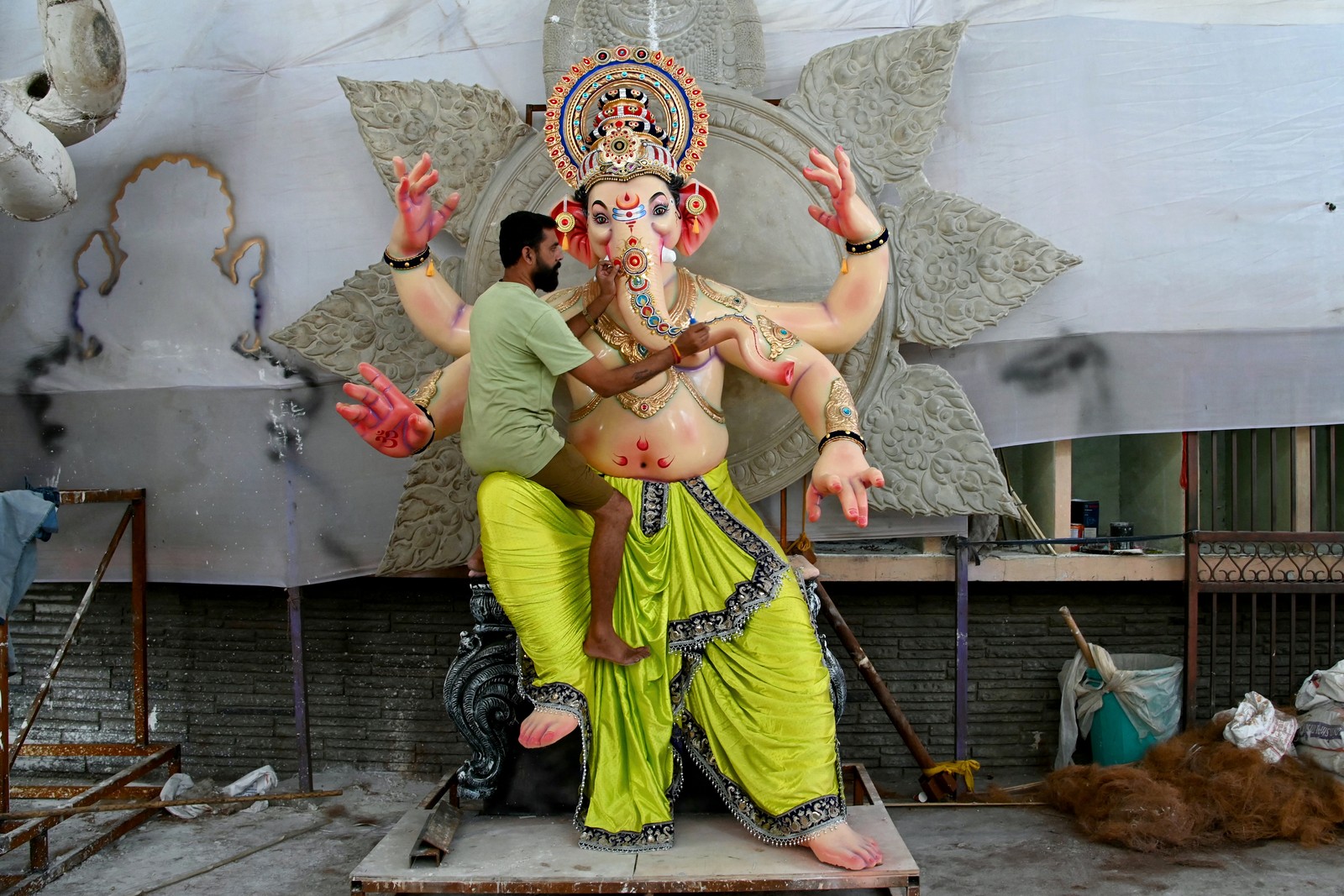 A man decorates an idol of the Hindu deity Ganesha in a workshop.