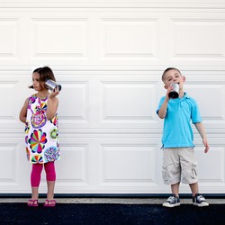 Two children talk with tin-can telephones.