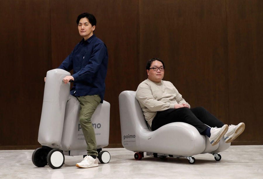 Two people sit on inflatable scooters.