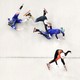 Three speed skaters slide and fall as they crash into one another at the end of a race, as one other remains standing, crossing the finish line.