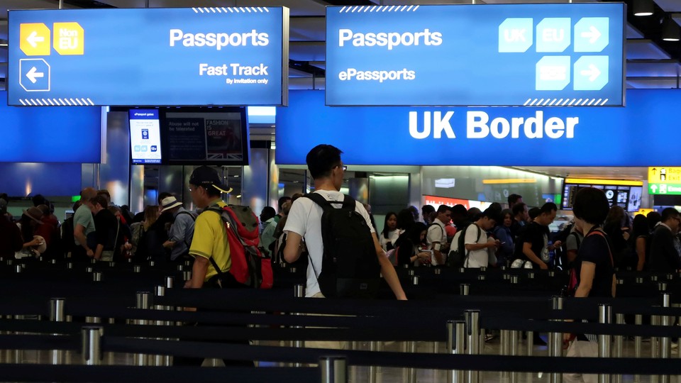 Travelers line up at the U.K. border control at Heathrow Airport in London on July 30, 2017. 