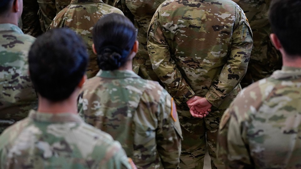 Photograph of the backs of US soldiers in camouflage.