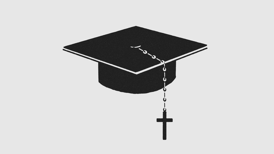 A black graduation cap with a rosary beaded-cross hanging from it.