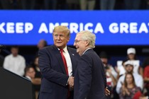 President Donald Trump attends Game 5 of the World Series with several congressional Republicans. He is waving at the crowd.