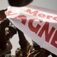 People holding a "Merci Wagner" sign