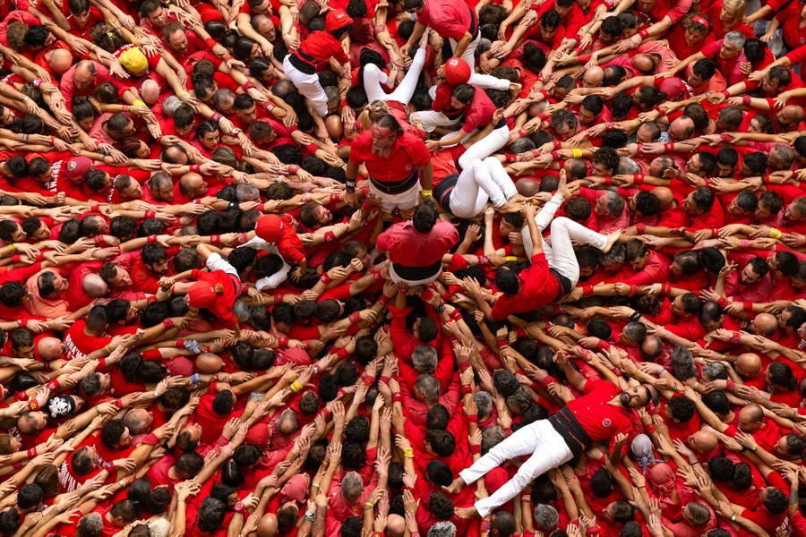 Several people lie scattered about on top of a large crowd smashed together after falling.