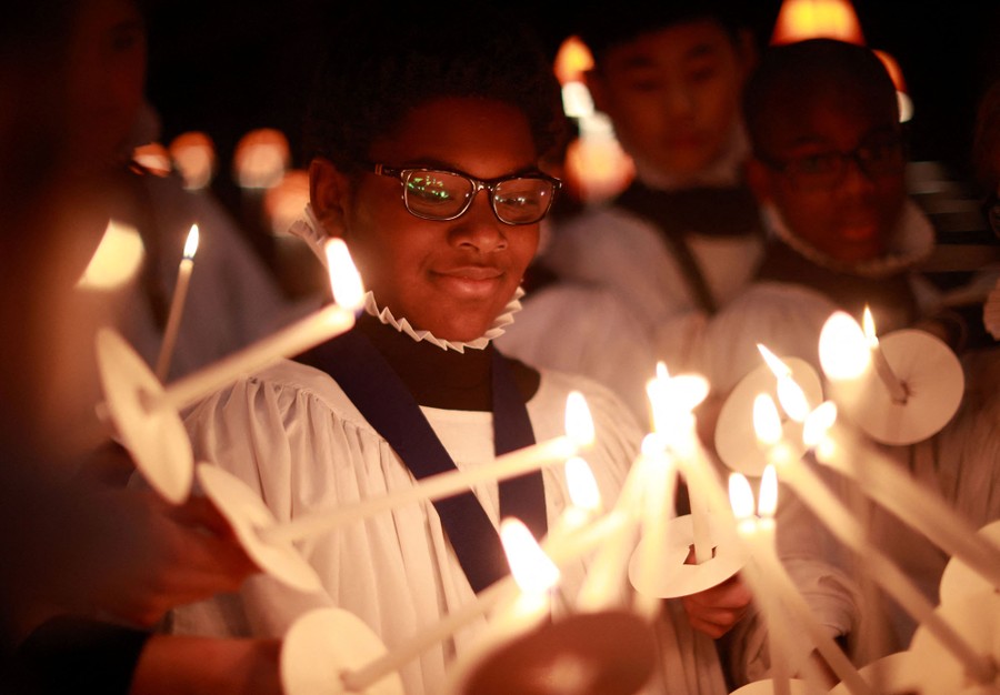 Members of a choir hold lit candles together.