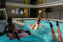 Color photograph of children swimming and playing in an outdoor pool