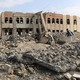 A man walks through the rubble of an air strike on a college in Saada, Yemen.