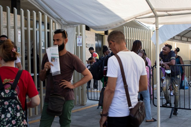 People waiting outside of an office building in Tapachula, Mexico