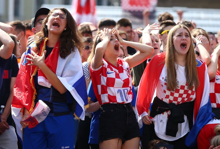 Soccer fans react with dismay after the other team scored a goal.