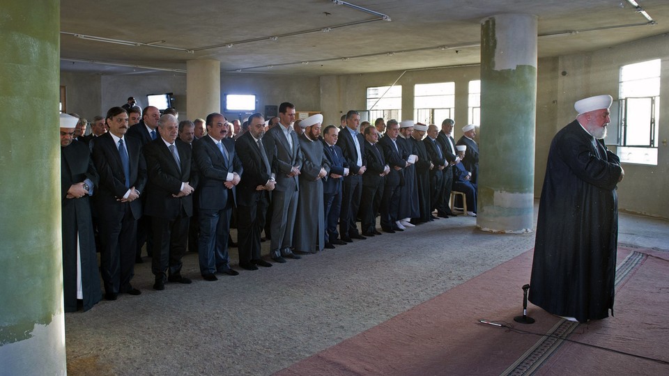 Syrian President Bashar al-Assad joins worshippers at the Saad ibn Muaaz Mosque in Daraya on Monday.