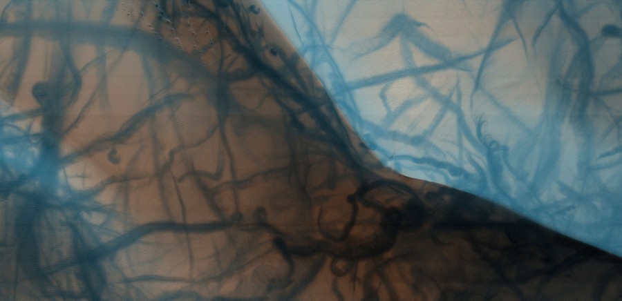 A dune ridge, streaked by swirling trails, seen from orbit