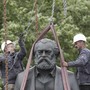 Workers in Berlin attach chains to lift a statue of Karl Marx.