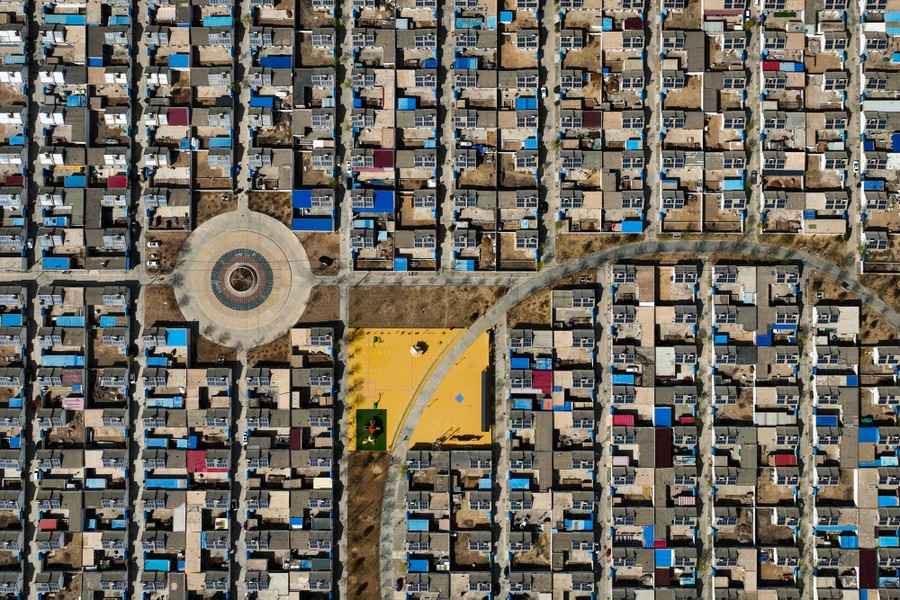 An aerial view of a grid of houses with roof-mounted solar panels