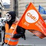 A masked demonstrator holds a flag of the French Democratic Confederation of Labour union (CFDT) in Paris during a national protest against the government's labour reforms on September 18, 2017. 