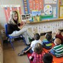 A teacher reads to sitting schoolchildren