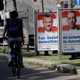 A cyclist passes posters featuring the far-right Freedom Party leader, Norbert Hofer, and former Interior Minister Herbert Kickl in Vienna.