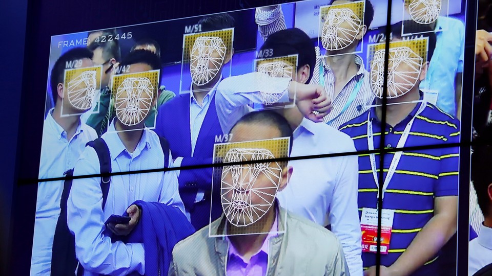 A screen shows the faces of several men as identified by Face++'s facial recognition software.