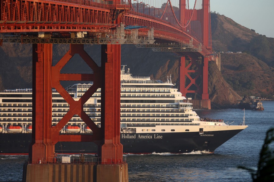 A cruise ship passes under the Golden Gate Bridge.
