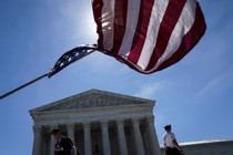 An American flag waving in front of the Supreme Court