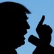 A silhouette of Donald Trump speaking into a microphone