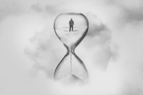A black-and-white drawing of the back of a man who appears inside an hourglass.